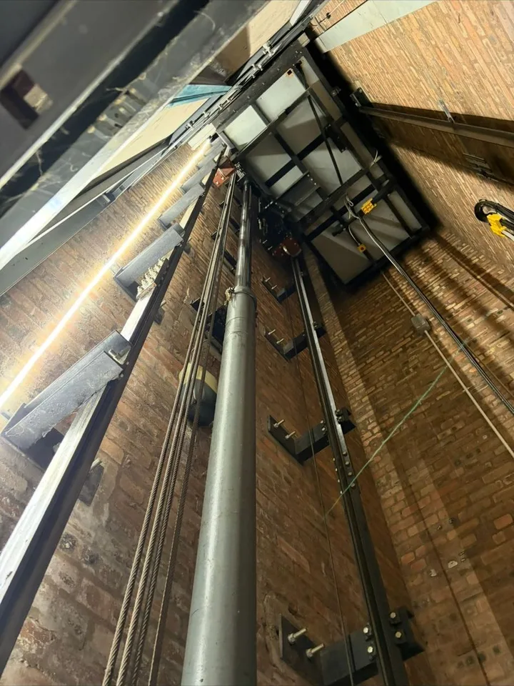 Hydraulic passenger lift ram and ropes in a brick shaft during a LOLER inspection